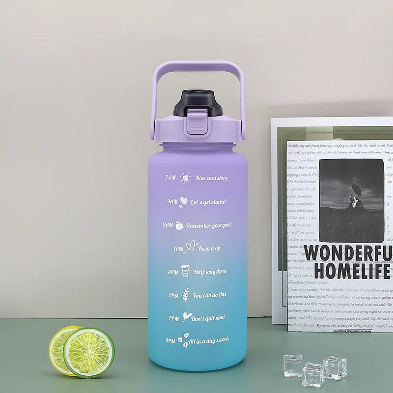Transparent 2L hydration water bottle with printed time tracker for monitoring daily water intake, great for fitness and sports.