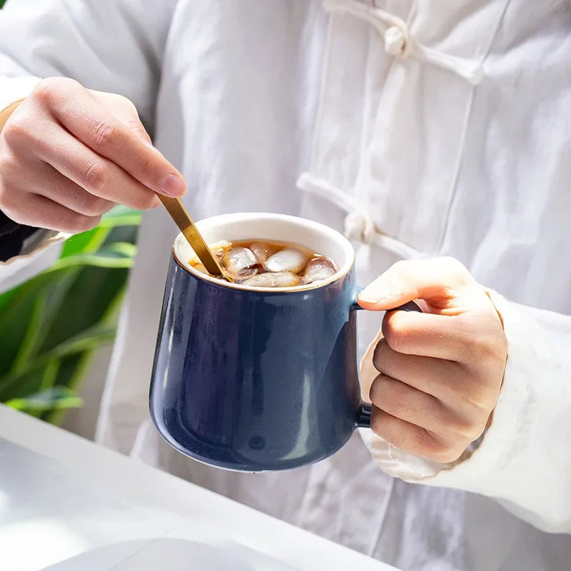 Side view of elegant European ceramic mug with gold-painted details