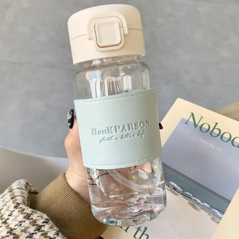 Portable 500ml school water bottle for kids, featuring a spill-proof design, pop-up drinking cover, and easy-carry handle.