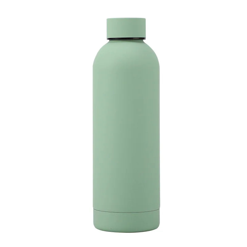 Portable stainless steel thermos bottle placed outdoors, ideal for hiking, camping, and adventure travel.