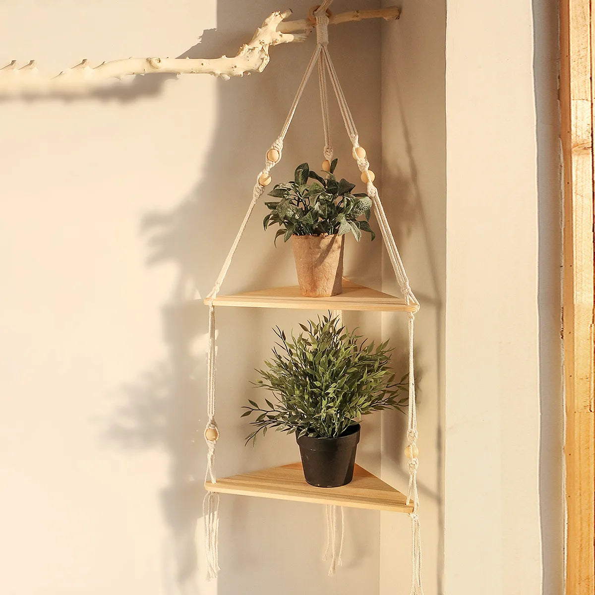 Boho wall shelf decorated with small potted plants and photo frames, mounted in a bright bedroom.